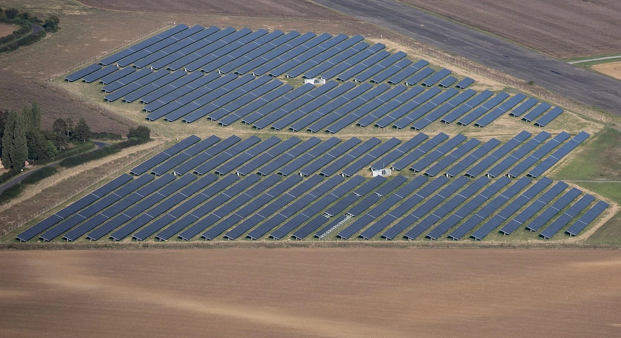Vista aérea de una granja de paneles solares rodeada de campos agrícolas