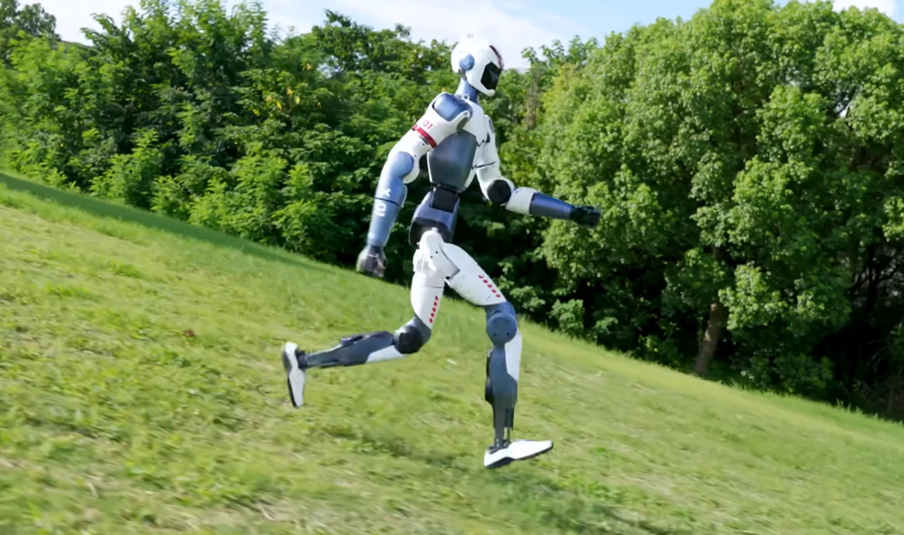 Robot humanoide Unitree R1 corriendo al aire libre sobre césped, demostrando su movilidad y equilibrio