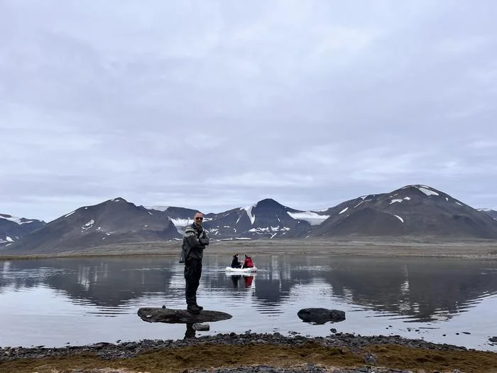 Equipo científico extrayendo núcleos de sedimentos desde una embarcación en el lago Wijdefjorden, Svalbard, mientras vigilan la presencia de osos polares.