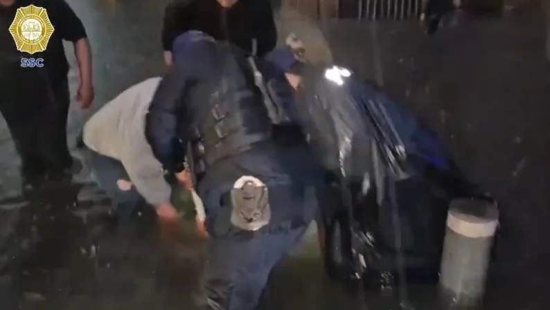 Policías de la SSC limpiando una alcantarilla durante una inundación en Ciudad de México