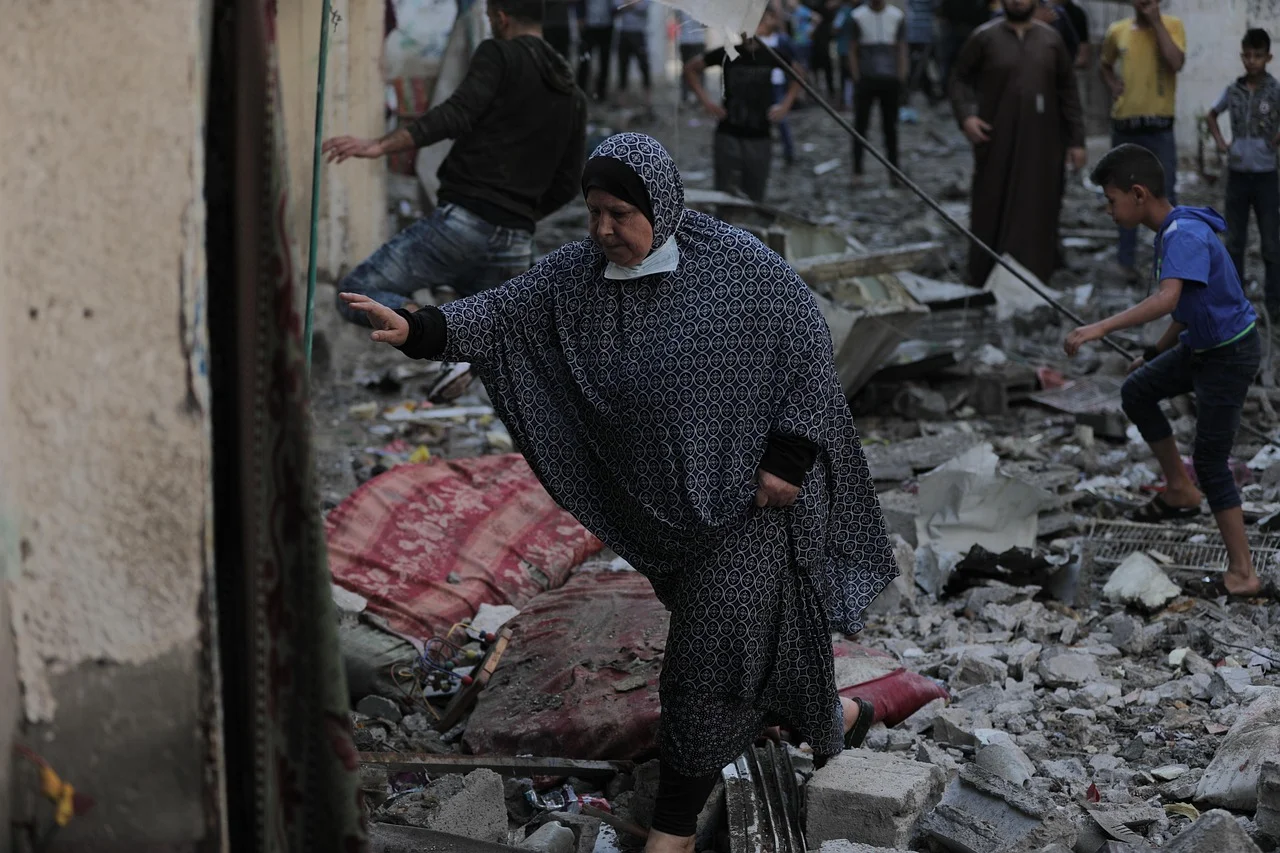 Mujer caminando entre escombros tras un bombardeo en Gaza