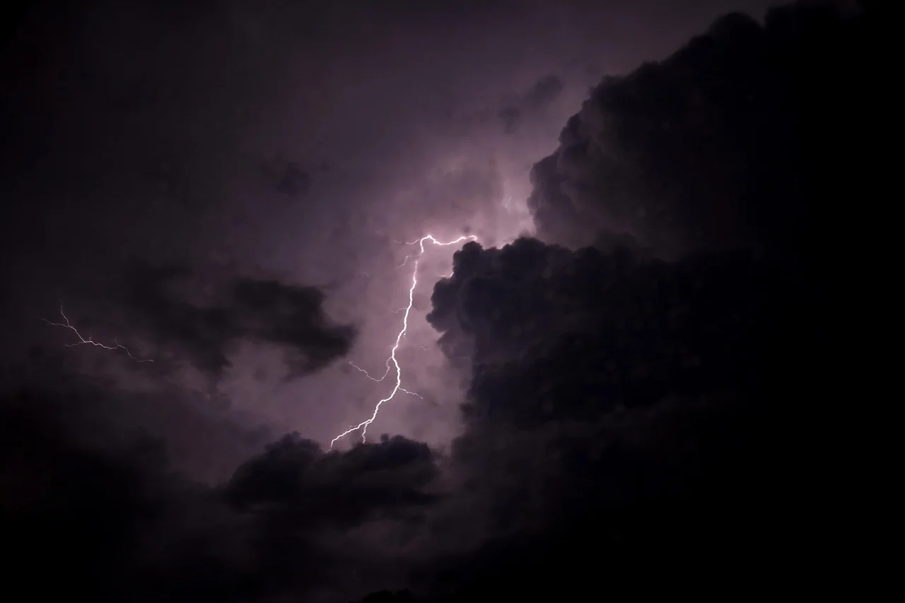Relámpago iluminando nubes oscuras durante una tormenta nocturna