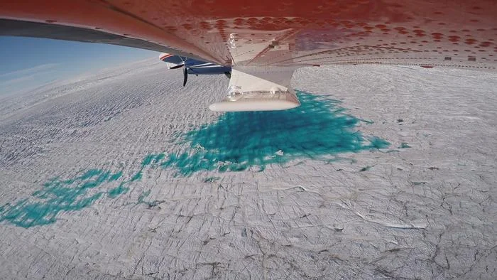Lago de agua de deshielo en la superficie del glaciar 79° N con grietas visibles