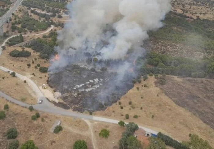 Vista aérea del incendio en Colmenar Viejo con humo y llamas avanzando sobre pastos y arbolado