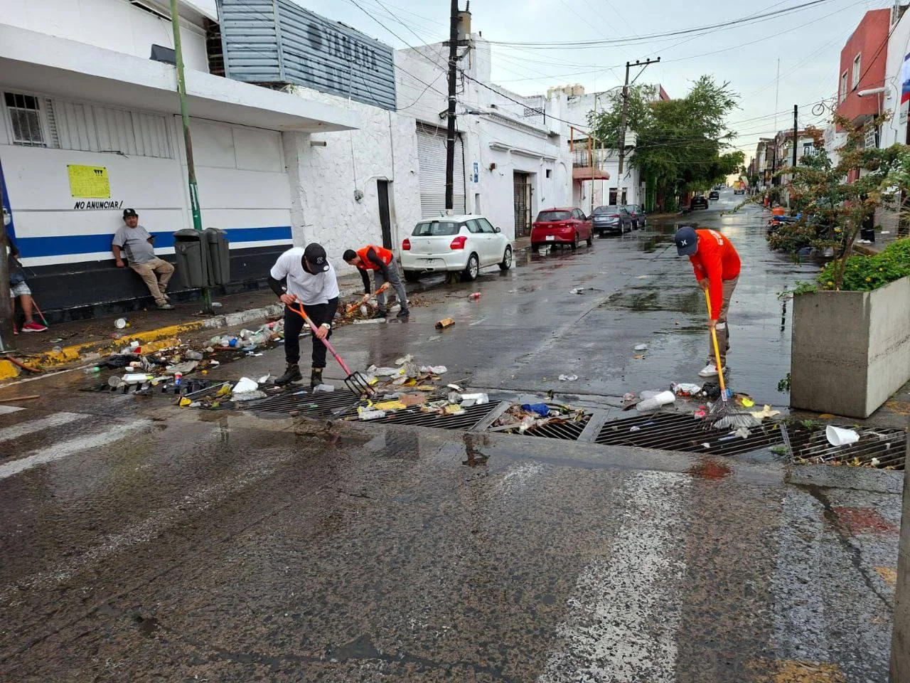 Trabajadores retirando basura de alcantarillas tras fuertes lluvias en Guadalajara