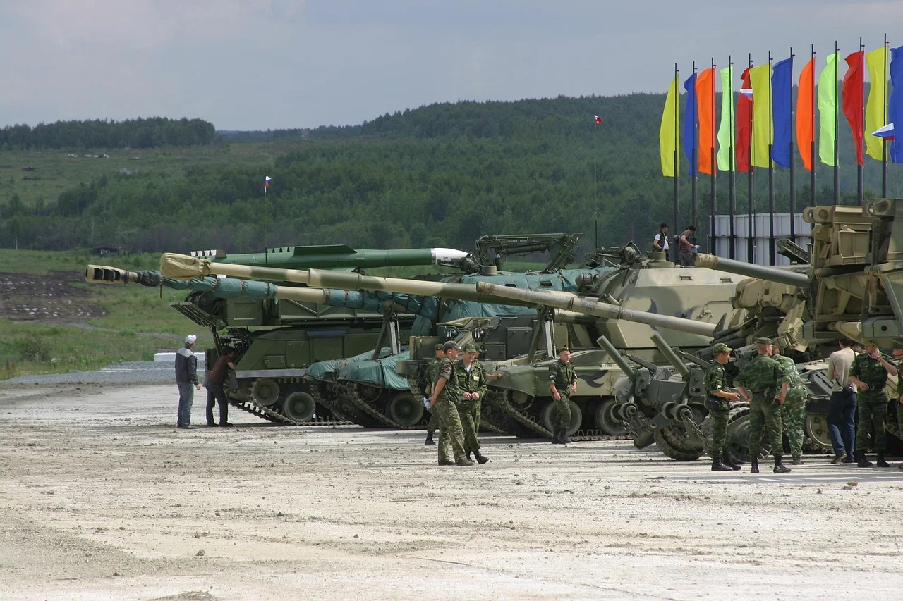 Vehículos militares y soldados rusos en una exhibición con banderas al fondo
