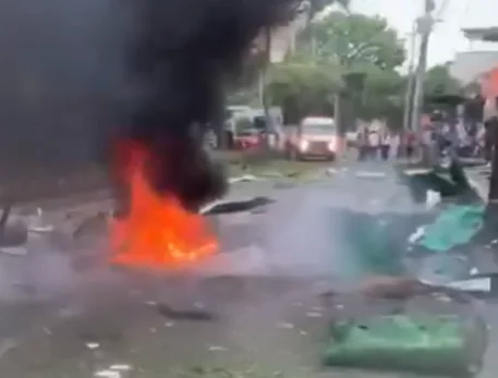 Escena tras la explosión en Cali, con llamas y humo en una calle afectada por el atentado