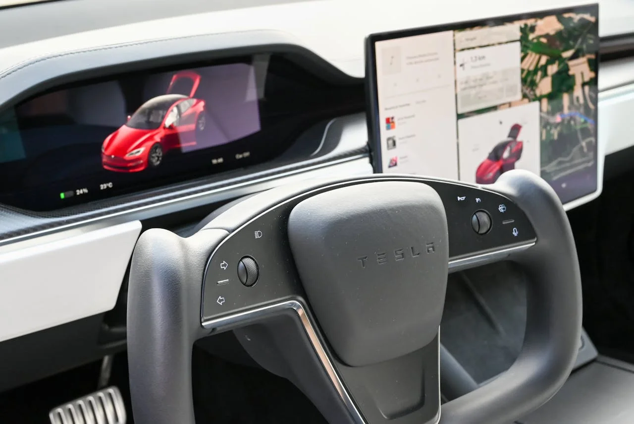 Volante tipo yugo y pantallas digitales en el interior de un coche eléctrico Tesla