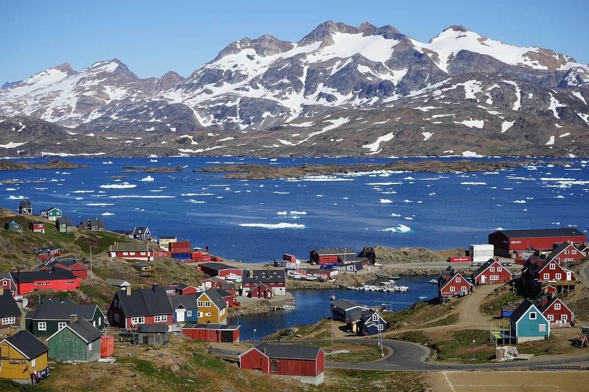 Vista panorámica de Tasiilaq, Groenlandia, con casas de colores y montañas nevadas