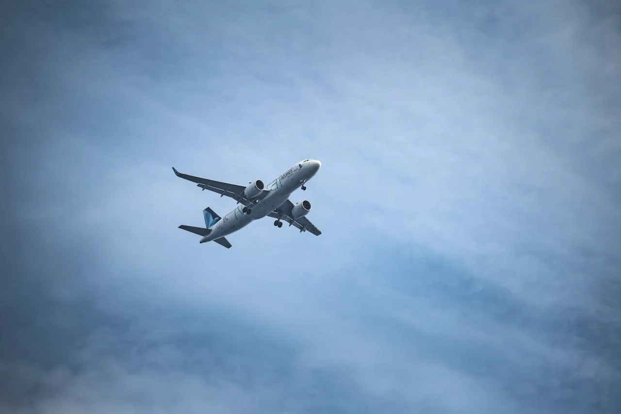 Avión comercial en vuelo sobre cielo parcialmente nublado