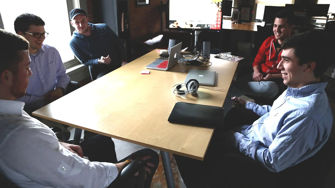 Jóvenes emprendedores de la generación Z reunidos en una oficina moderna, trabajando en equipo en un proyecto tecnológico
