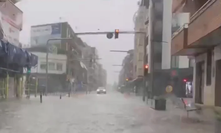 Calle inundada en Catalunya tras lluvias intensas con tráfico interrumpido y semáforos encendidos
