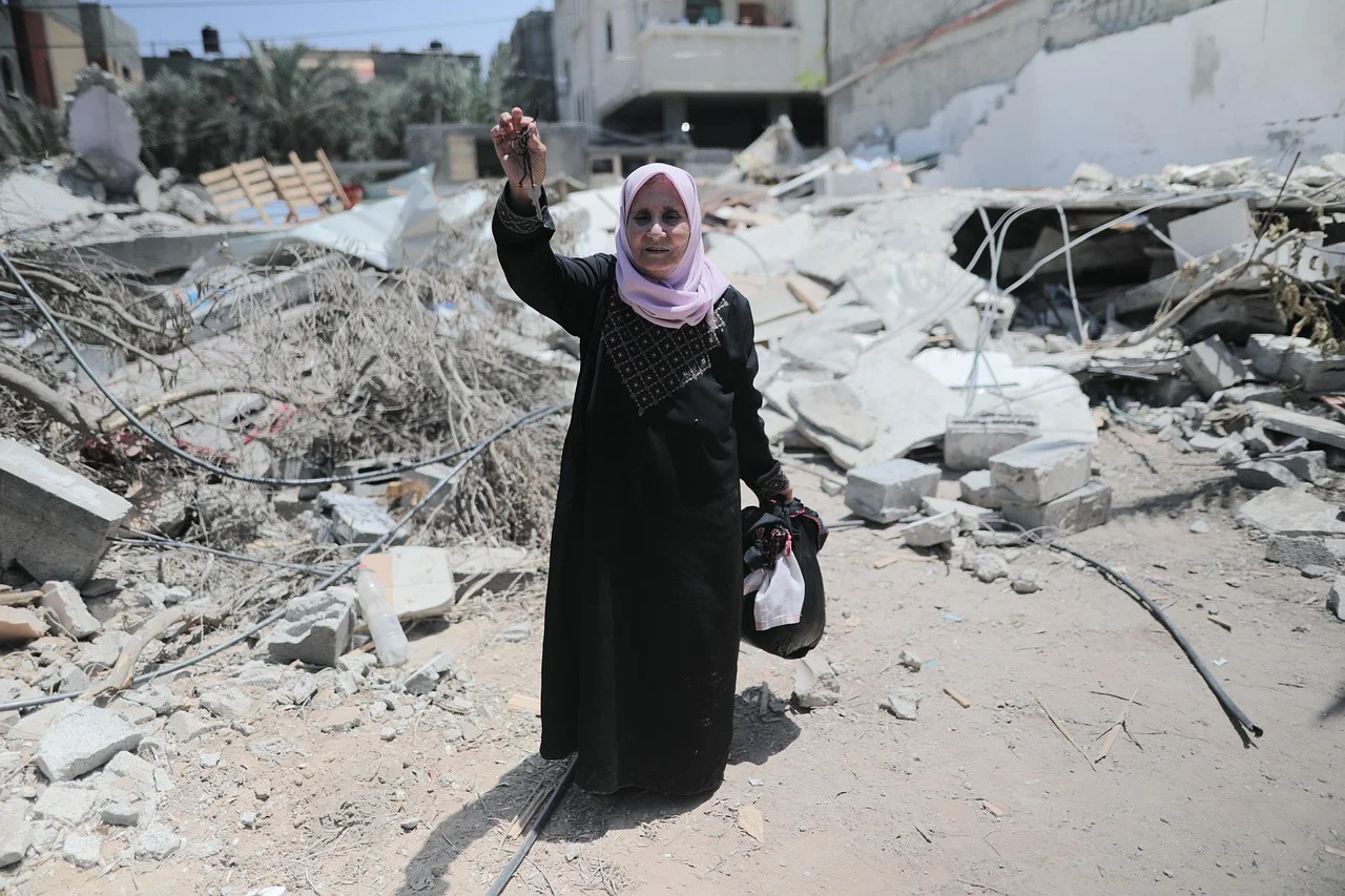 Mujer en Gaza sostiene llaves entre los escombros de una vivienda destruida tras los bombardeos