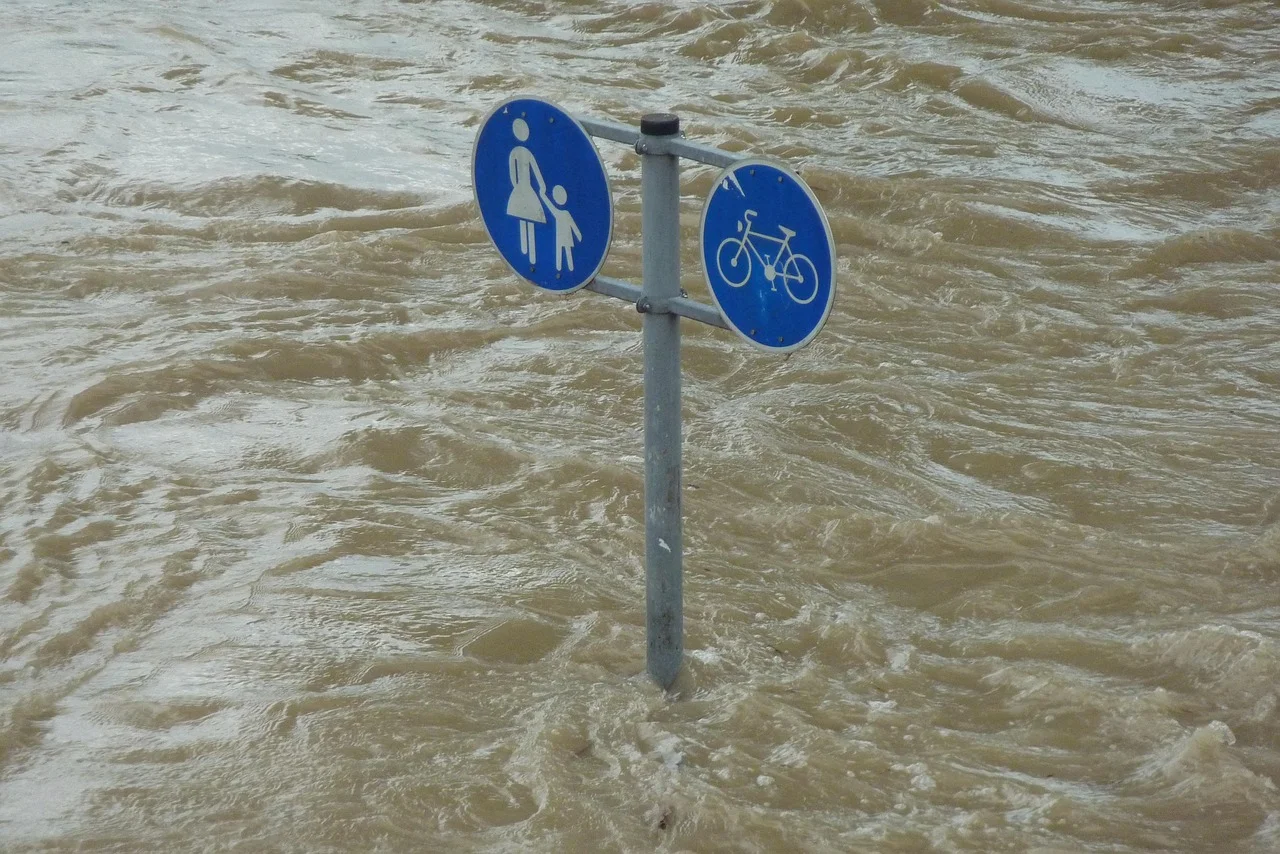 Señal de peatones y bicicletas sumergida por inundaciones debido a fenómenos climáticos extremos
