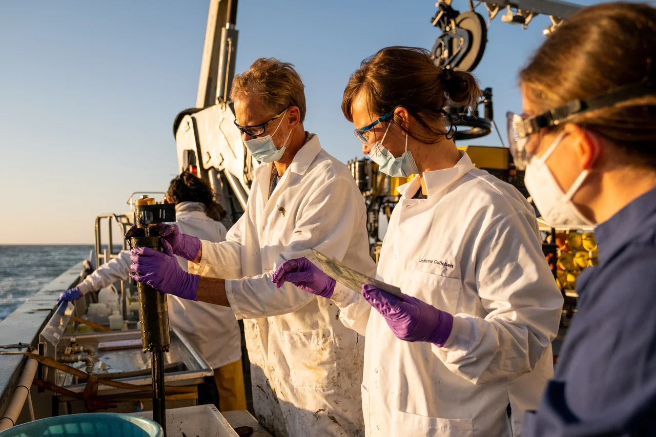 Investigadores clasificando núcleos de sedimentos recuperados desde el fondo marino durante la expedición con el ROV SuBastian