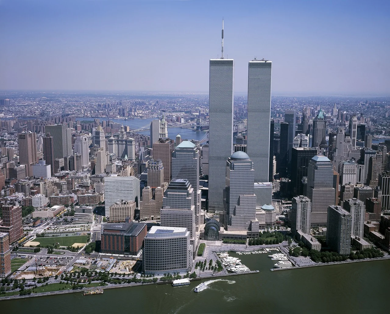 Vista aérea panorámica de Manhattan con las Torres Gemelas del World Trade Center destacando en el centro, rodeadas de rascacielos y el río Hudson en primer plano