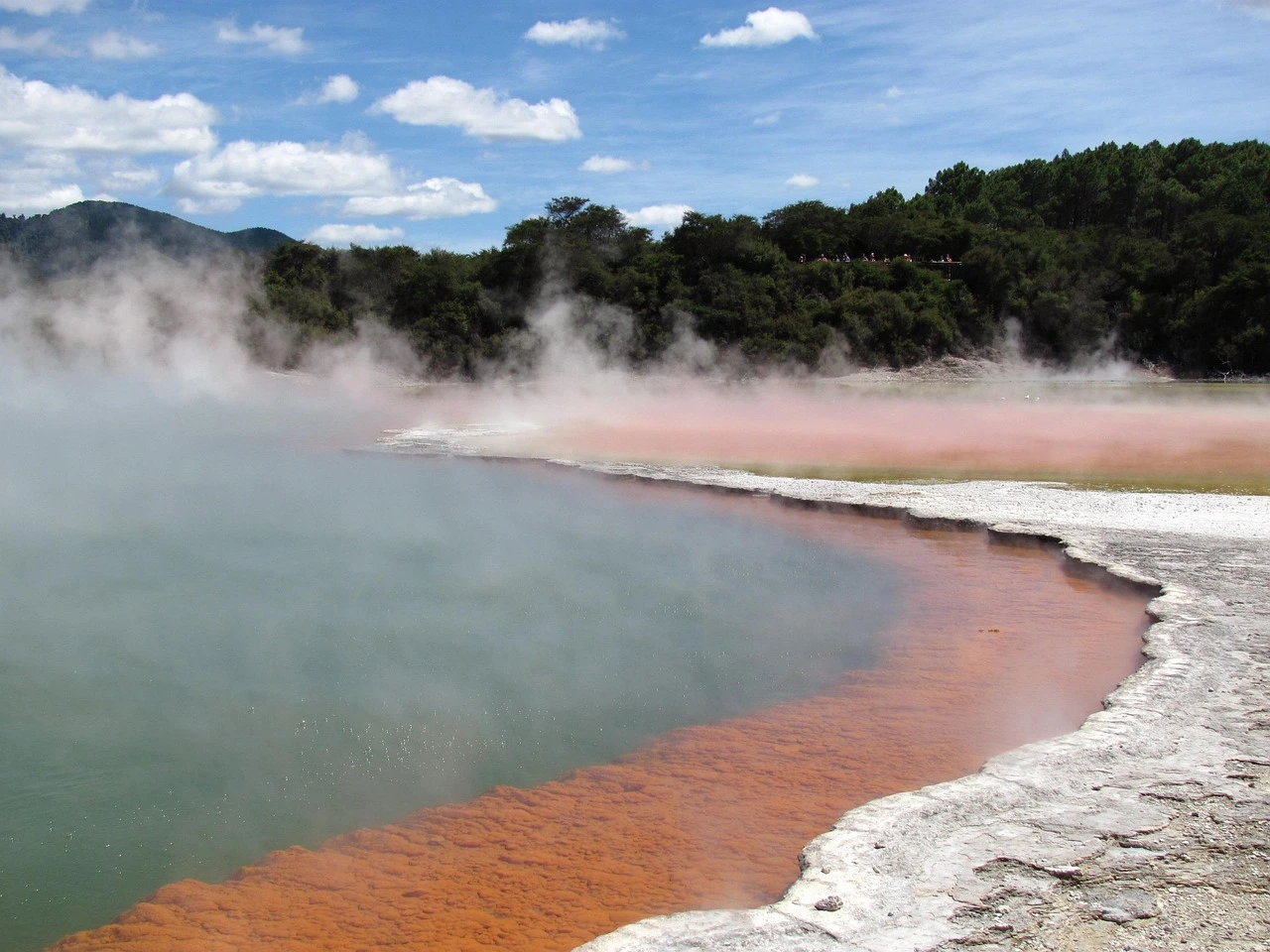 Laguna termal con depósitos minerales verdes y amarillos en Yellowstone