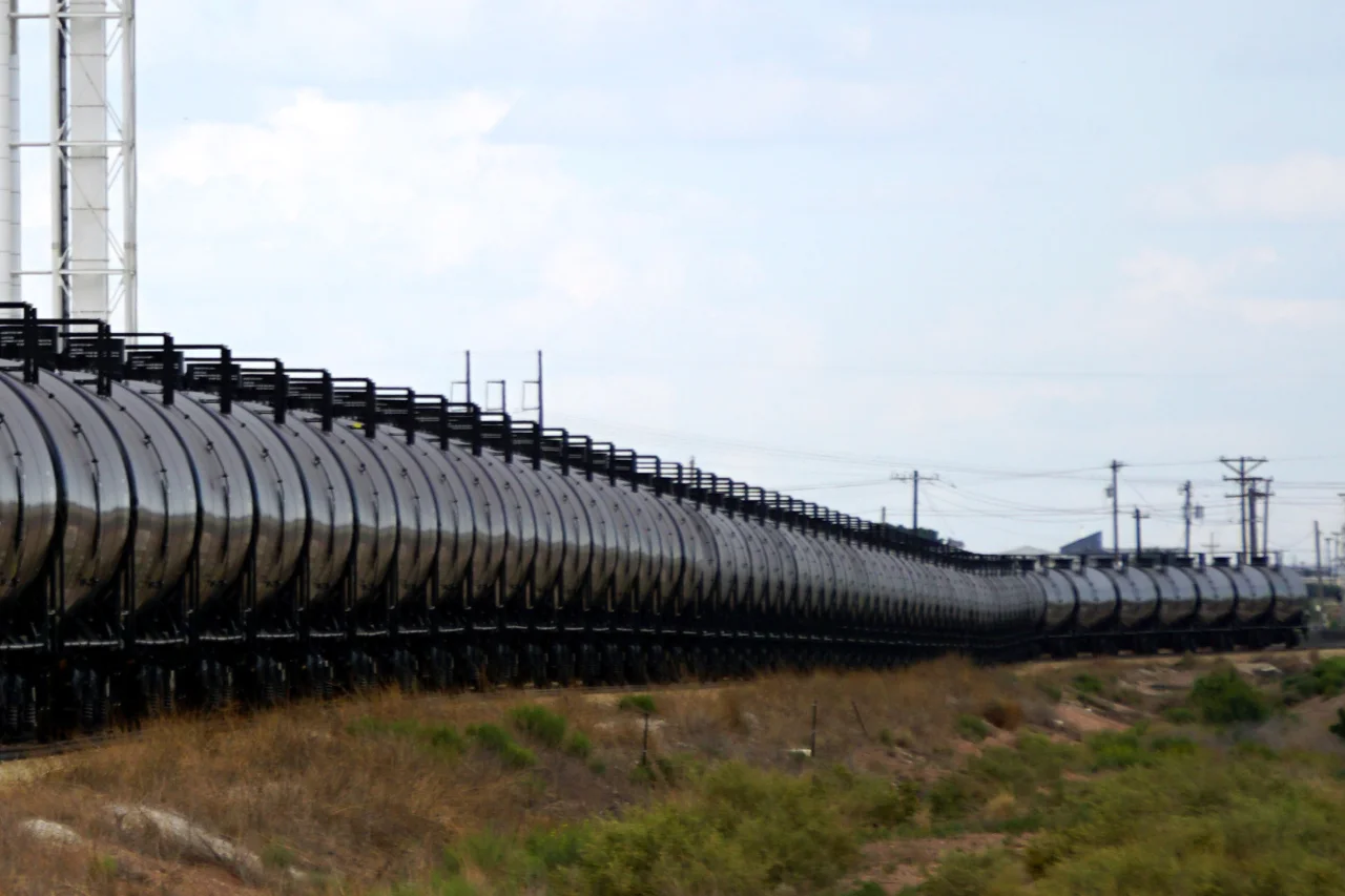Fila de vagones cisterna de tren para transporte de combustible a lo largo de la vía