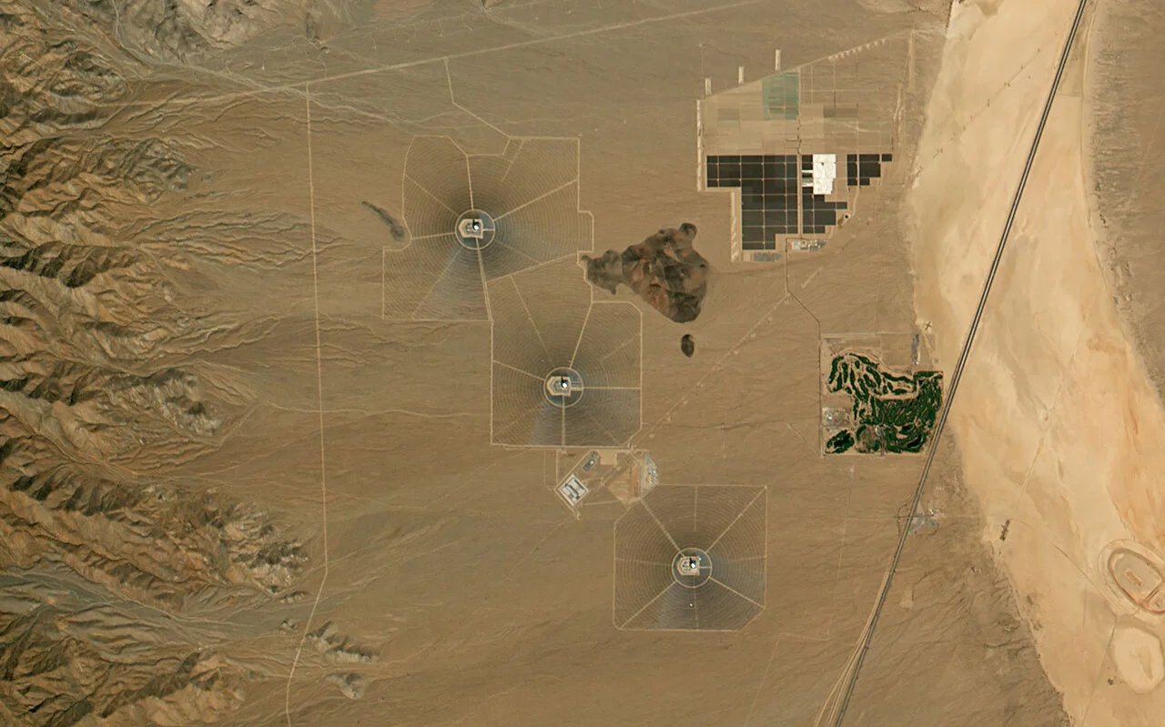 Imagen satelital del complejo solar Ivanpah en el desierto de Mojave, mostrando sus tres torres y campos circulares de heliostatos