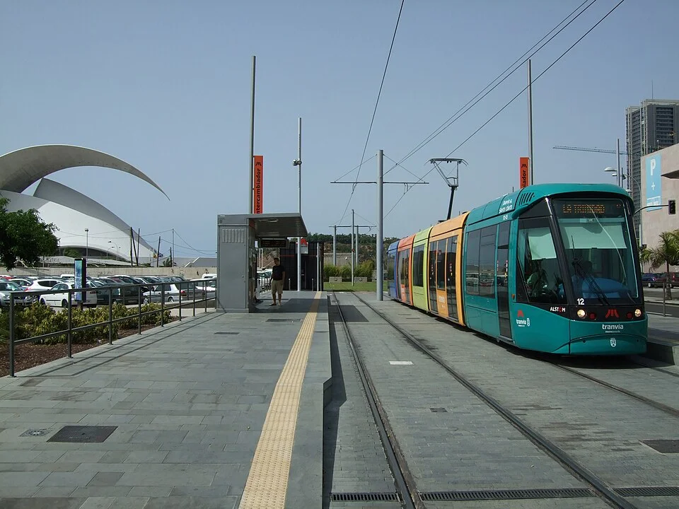 Tranvía circulando por el intercambiador de Tenerife con el Auditorio de Tenerife visible al fondo