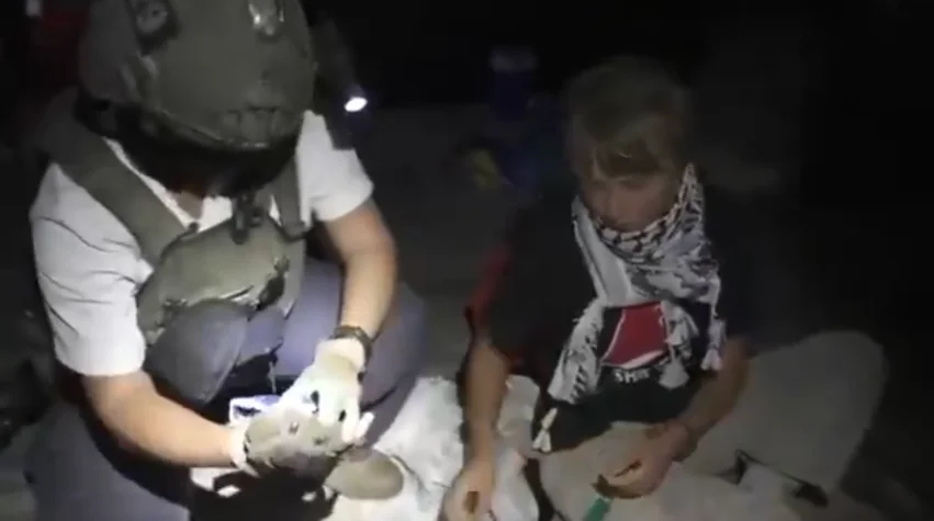 Activista Greta Thunberg junto a un soldado tras la interceptación de la flotilla Global Sumud en aguas internacionales