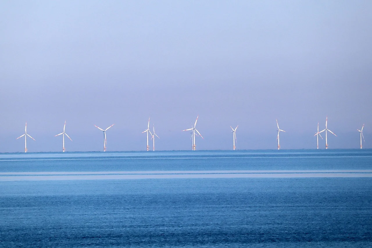 Parque eólico marino con aerogeneradores en el horizonte sobre aguas tranquilas