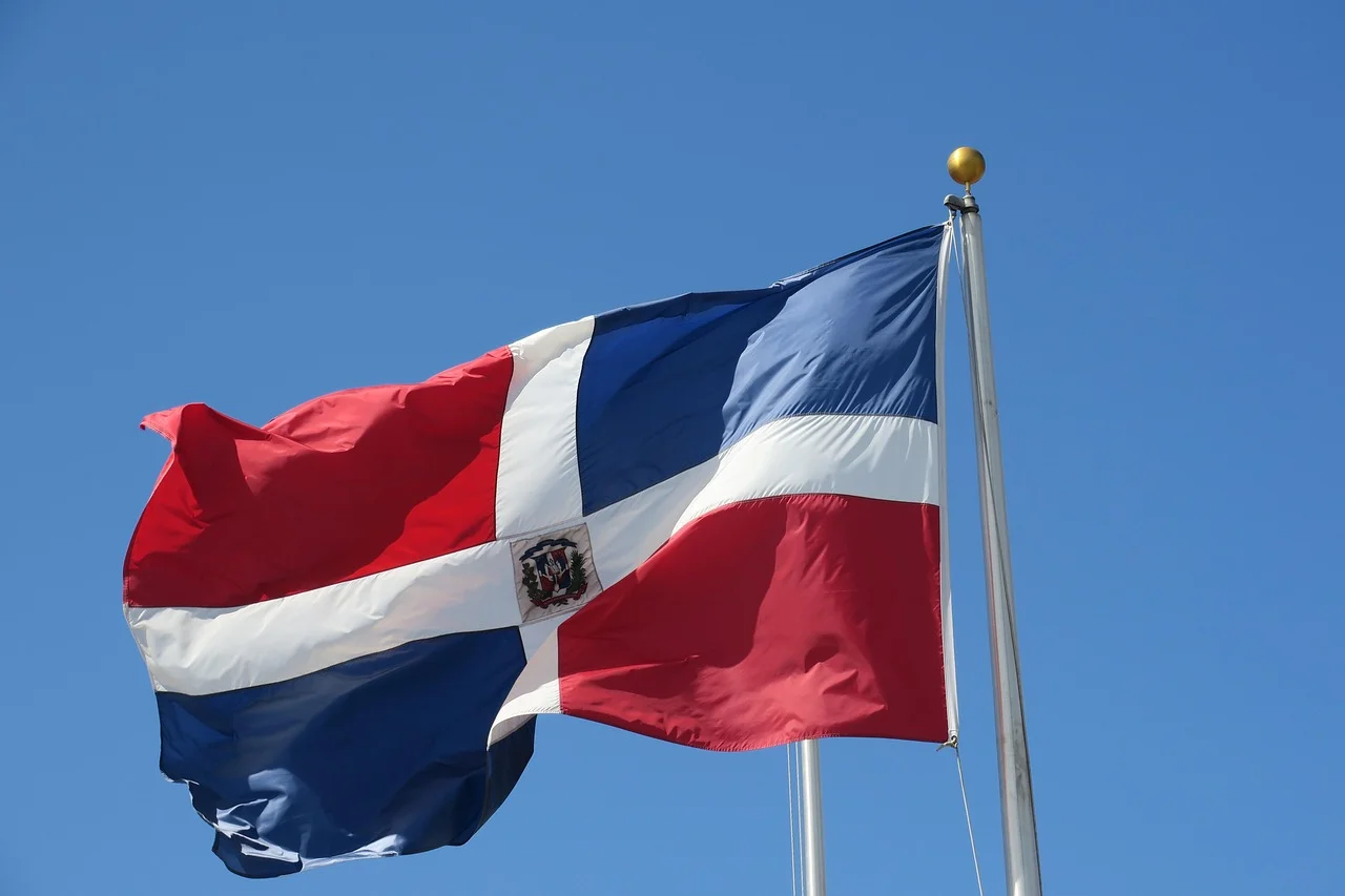 Bandera de la República Dominicana ondeando sobre un cielo despejado