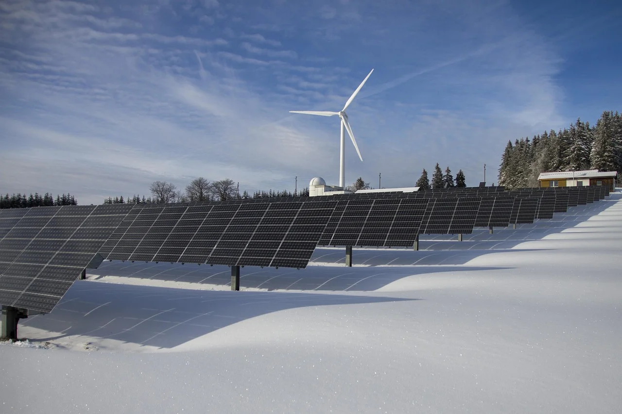 Paneles solares y turbina eólica en un paisaje nevado