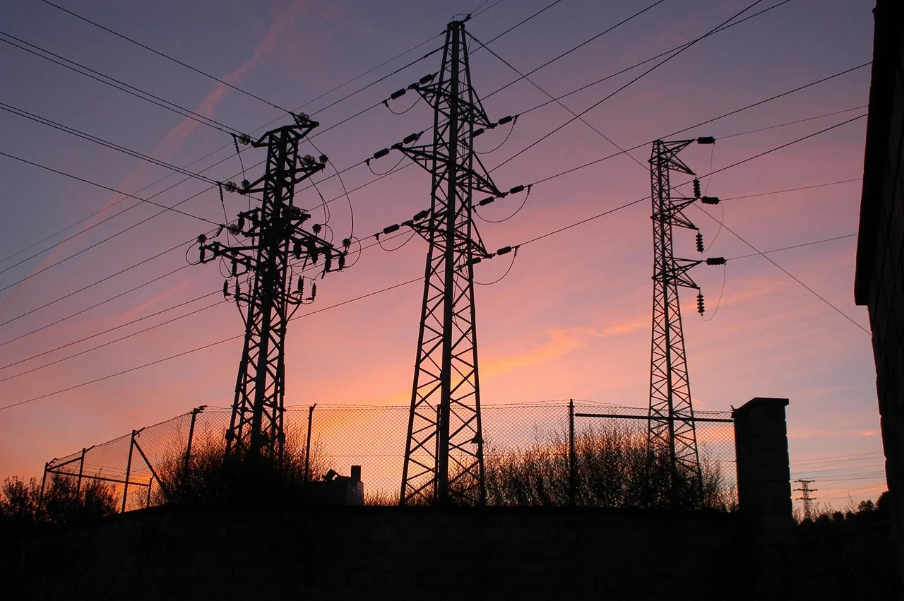 Tendidos eléctricos al amanecer con el cielo teñido de tonos rosados y naranjas