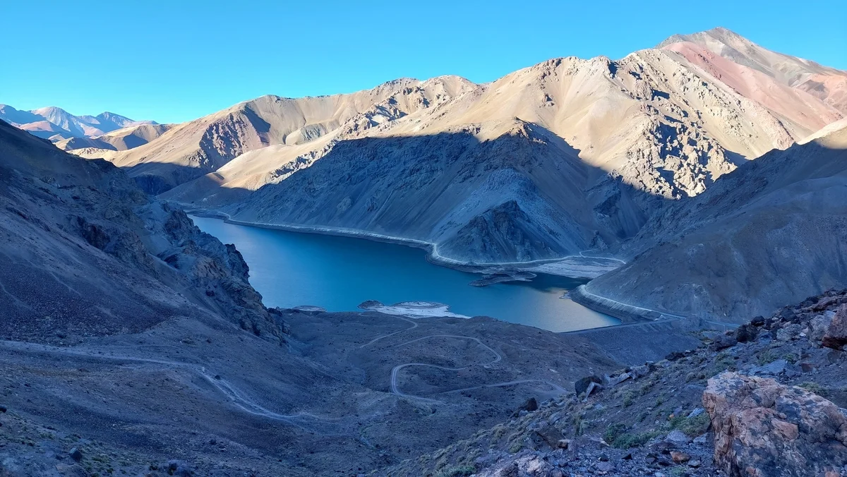 Embalse de La Laguna en los Andes de Chile, rodeado de montañas secas y alimentado por el agua de deshielo