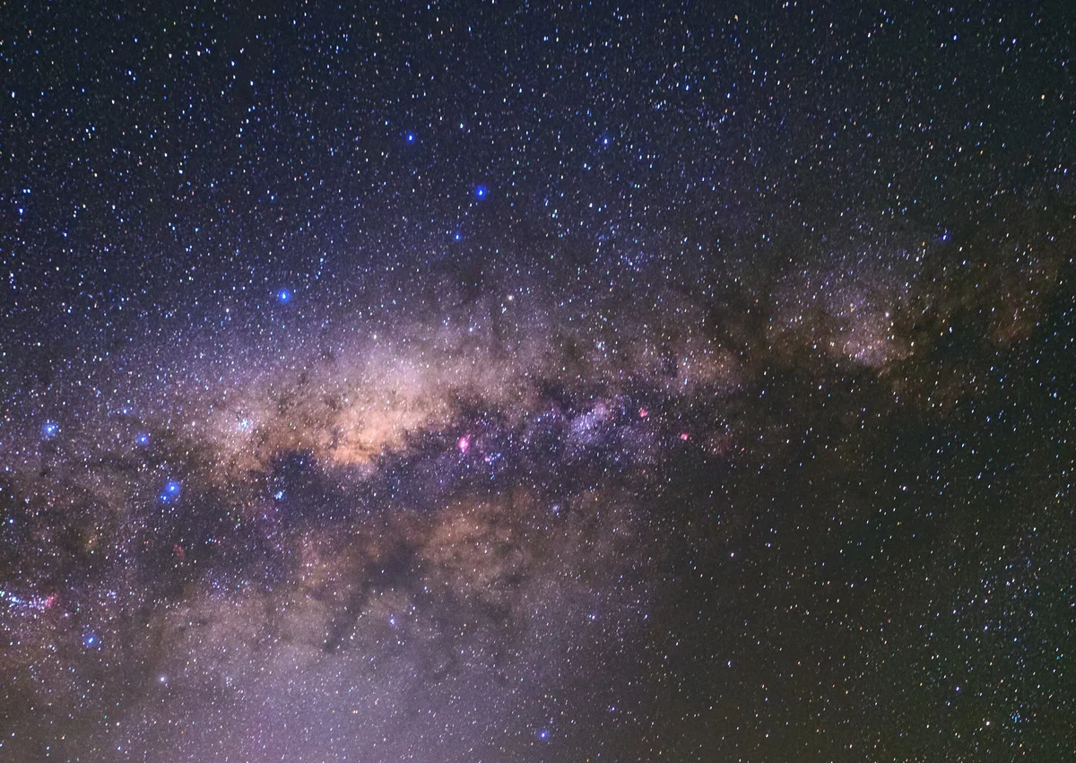 Cielo estrellado con una tenue luz zodiacal formando un resplandor pálido sobre el horizonte