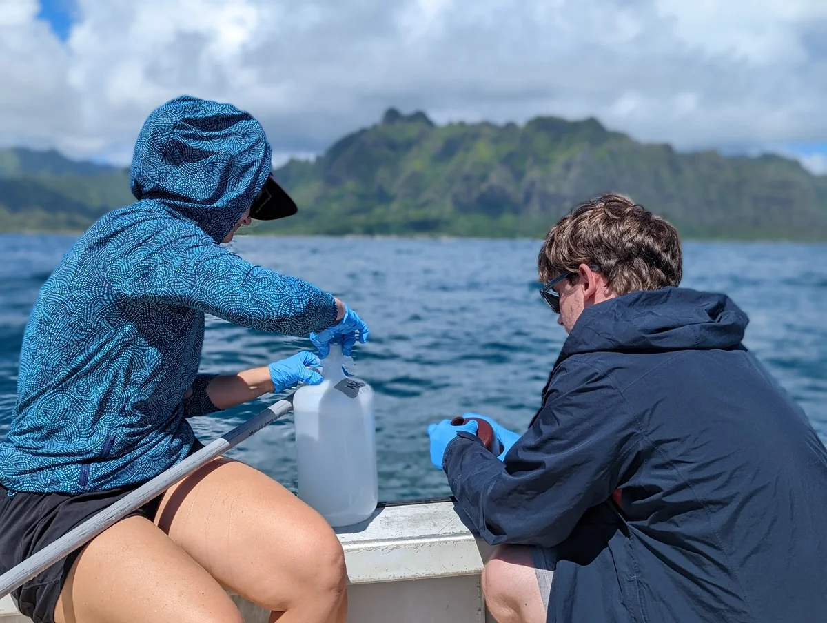 Investigadores recogiendo agua de mar superficial durante un muestreo en Kāneʻohe