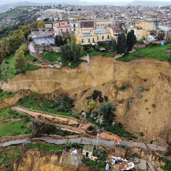 Casas y caminos dañados por un desprendimiento de ladera con suelo hundido