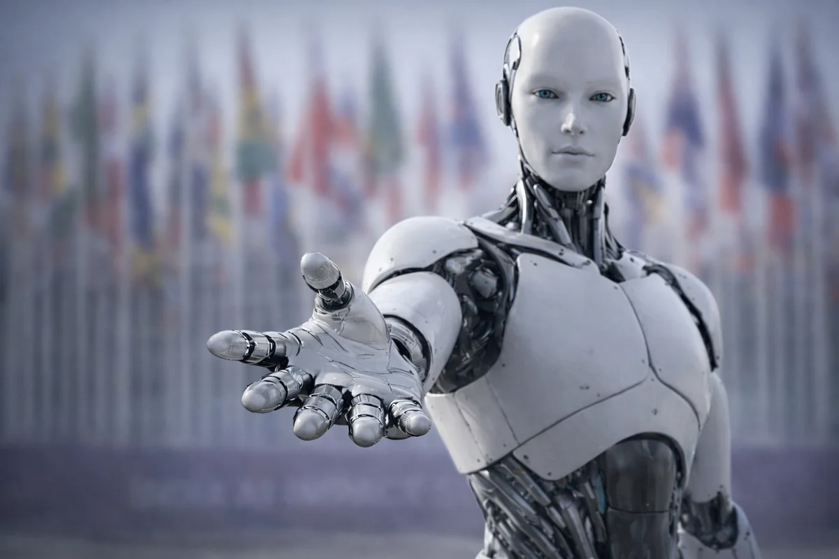 Robot humanoide en primer plano con banderas desenfocadas en la cumbre de IA en Nueva Delhi.