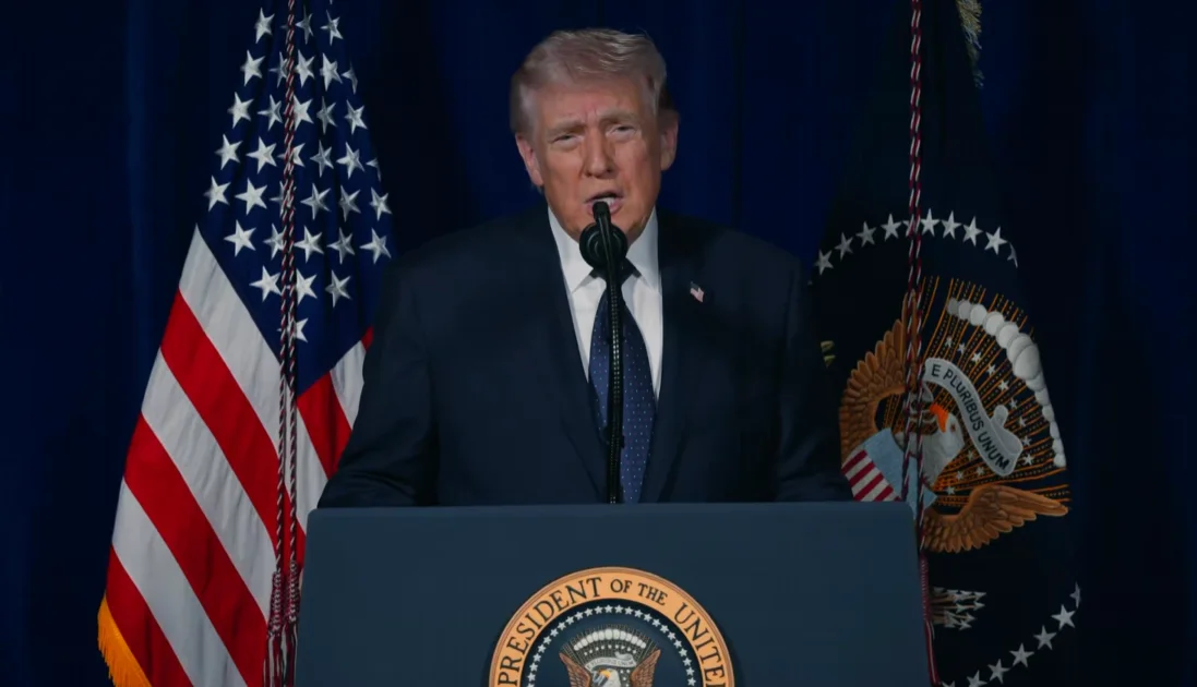 Donald Trump ofrece un discurso desde un podio presidencial con banderas de Estados Unidos al fondo