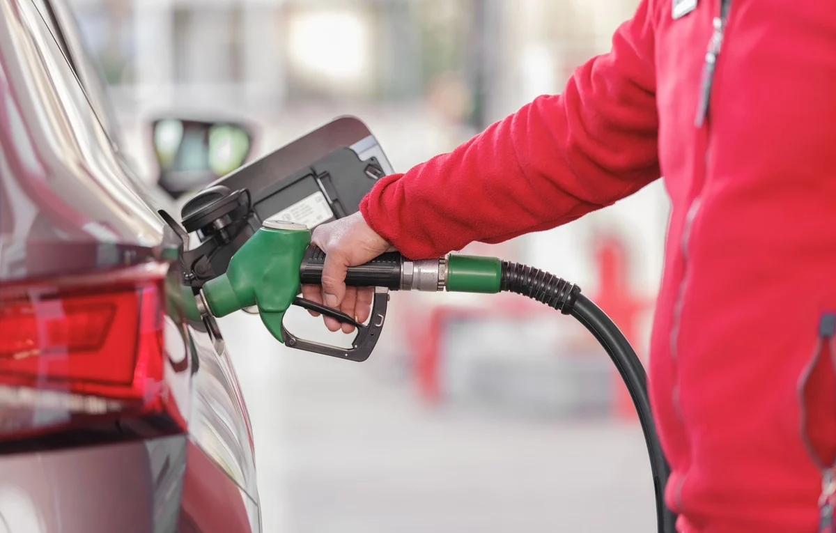 Persona repostando combustible en una gasolinera