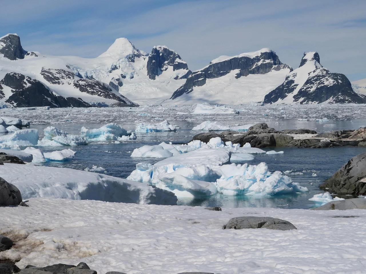 Paisaje helado de la Antártida con icebergs y montañas nevadas.