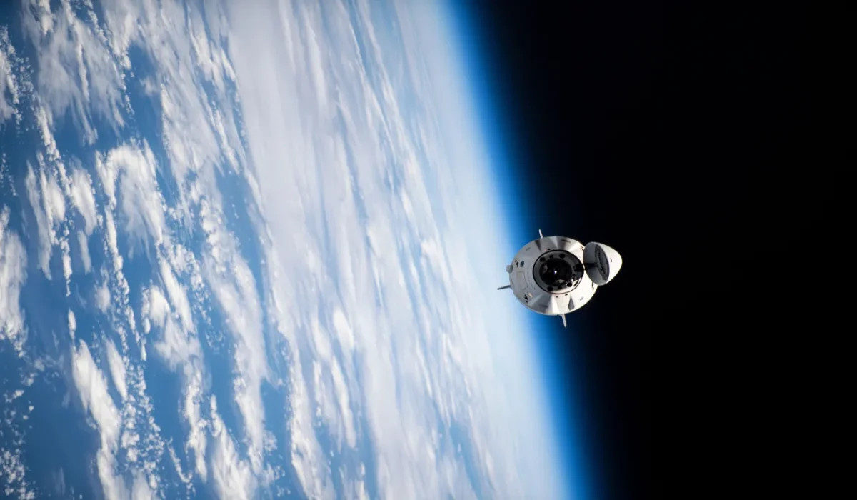 Nave espacial Dragon CRS-32 acercándose a la estación espacial internacional sobre la atmósfera terrestre