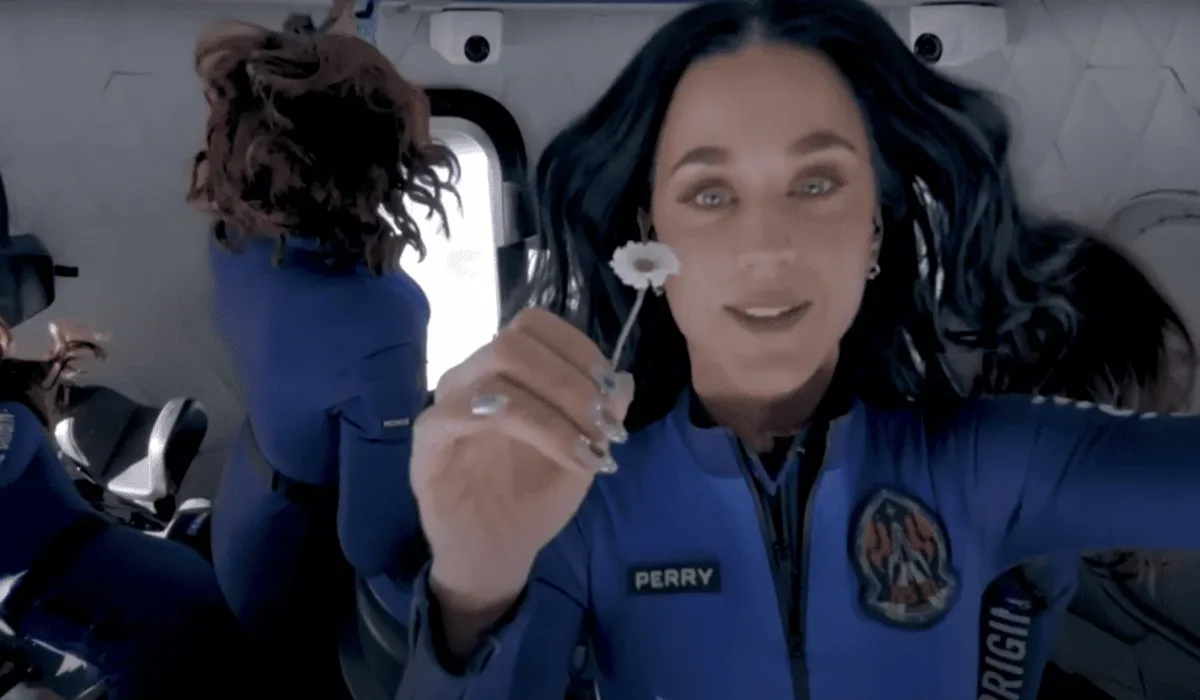Katy Perry en gravedad cero dentro de la cápsula de Blue Origin, sosteniendo una flor mientras flota en el espacio junto a otras pasajeras