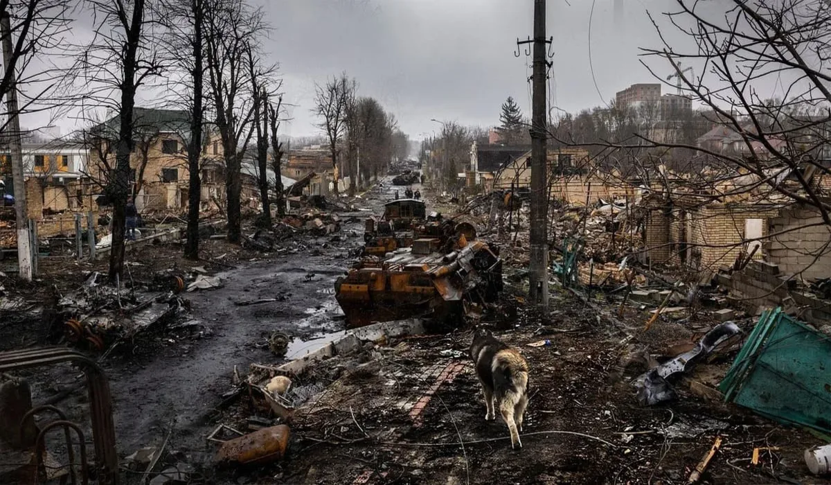 Vista de una ciudad devastada por la guerra, con vehículos destruidos y calles cubiertas de escombros