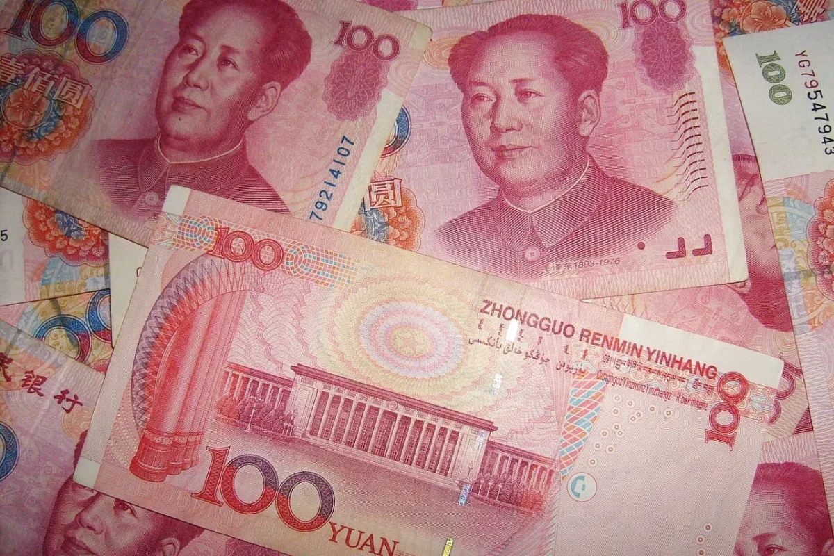 Billetes de 100 yuanes chinos con el retrato de Mao Zedong, mostrando detalles de diseño y colores vibrantes.