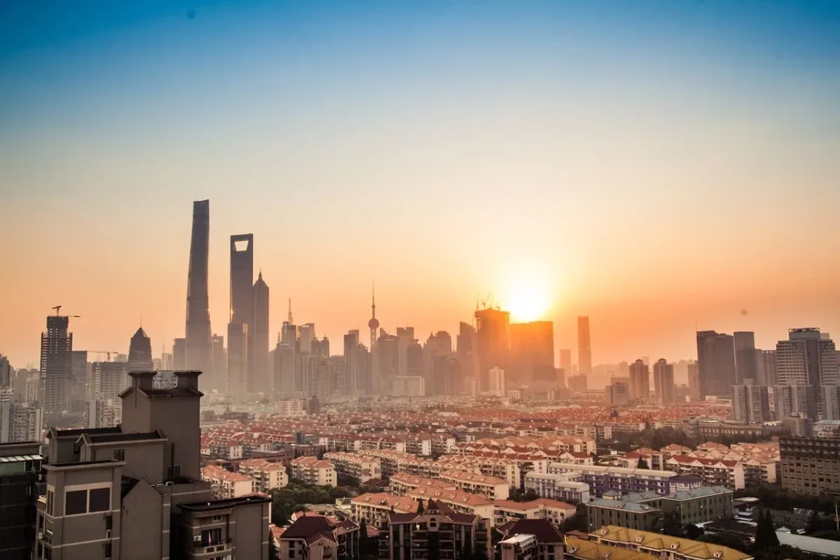 Vista panorámica del horizonte de Shanghái al amanecer, con rascacielos y viviendas bajo un cielo despejado.