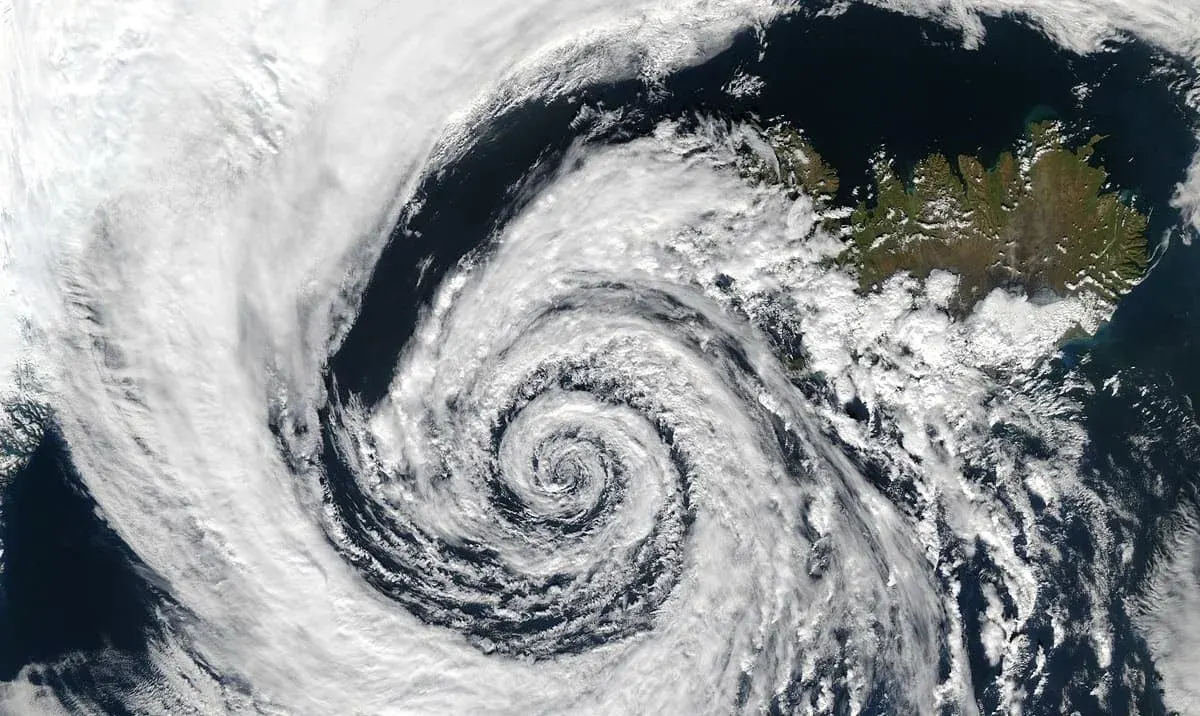 Imagen satelital de una depresión atmosférica cerca de Islandia, con un patrón de nubes en espiral sobre el océano.