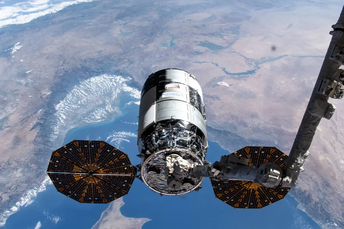 Nave Cygnus de Northrop Grumman acoplada a la Estación Espacial Internacional con la Tierra de fondo.
