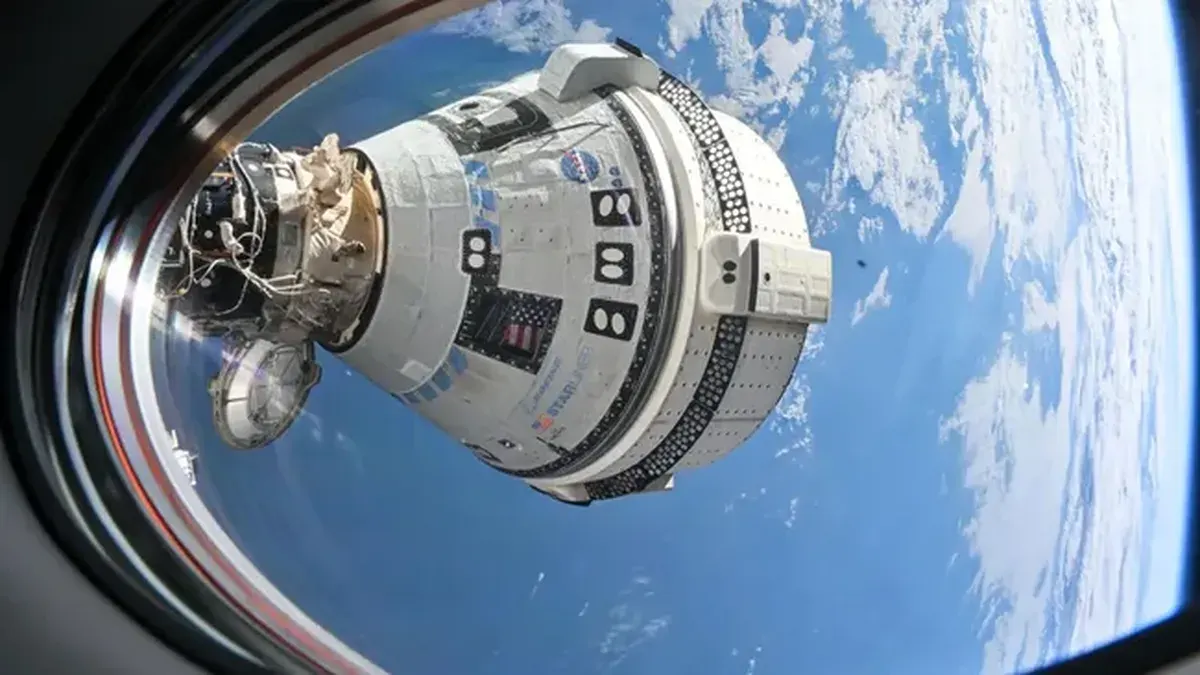 Cápsula Starliner vista desde una ventana de la EEI con la Tierra de fondo