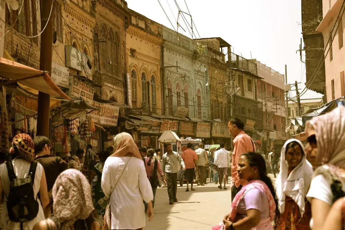 Calle concurrida de una ciudad india bajo una atmósfera densa y calurosa, posible presencia de contaminación ambiental