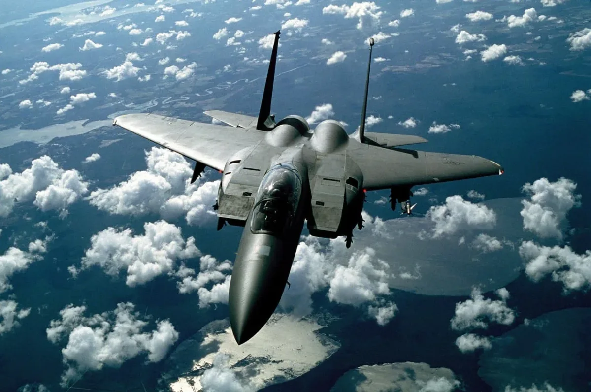 Avión de combate volando a gran altitud sobre formaciones nubosas
