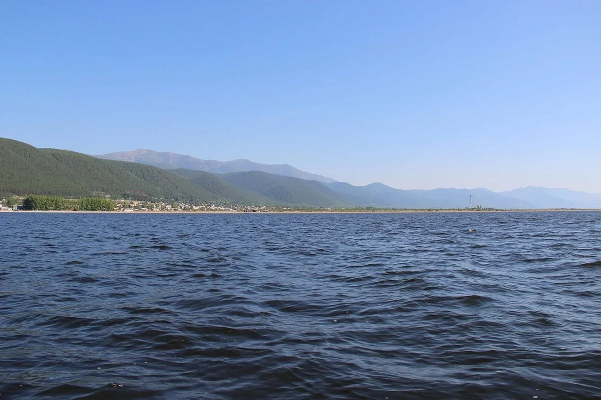 Lago Baikal con superficie ondulada, montaña boscosa y cielo despejado