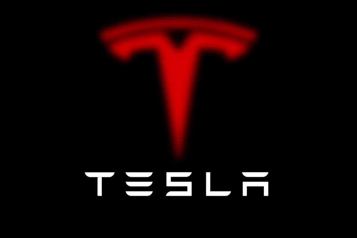 Logo de Tesla en rojo difuminado sobre fondo negro con la palabra TESLA en blanco al frente