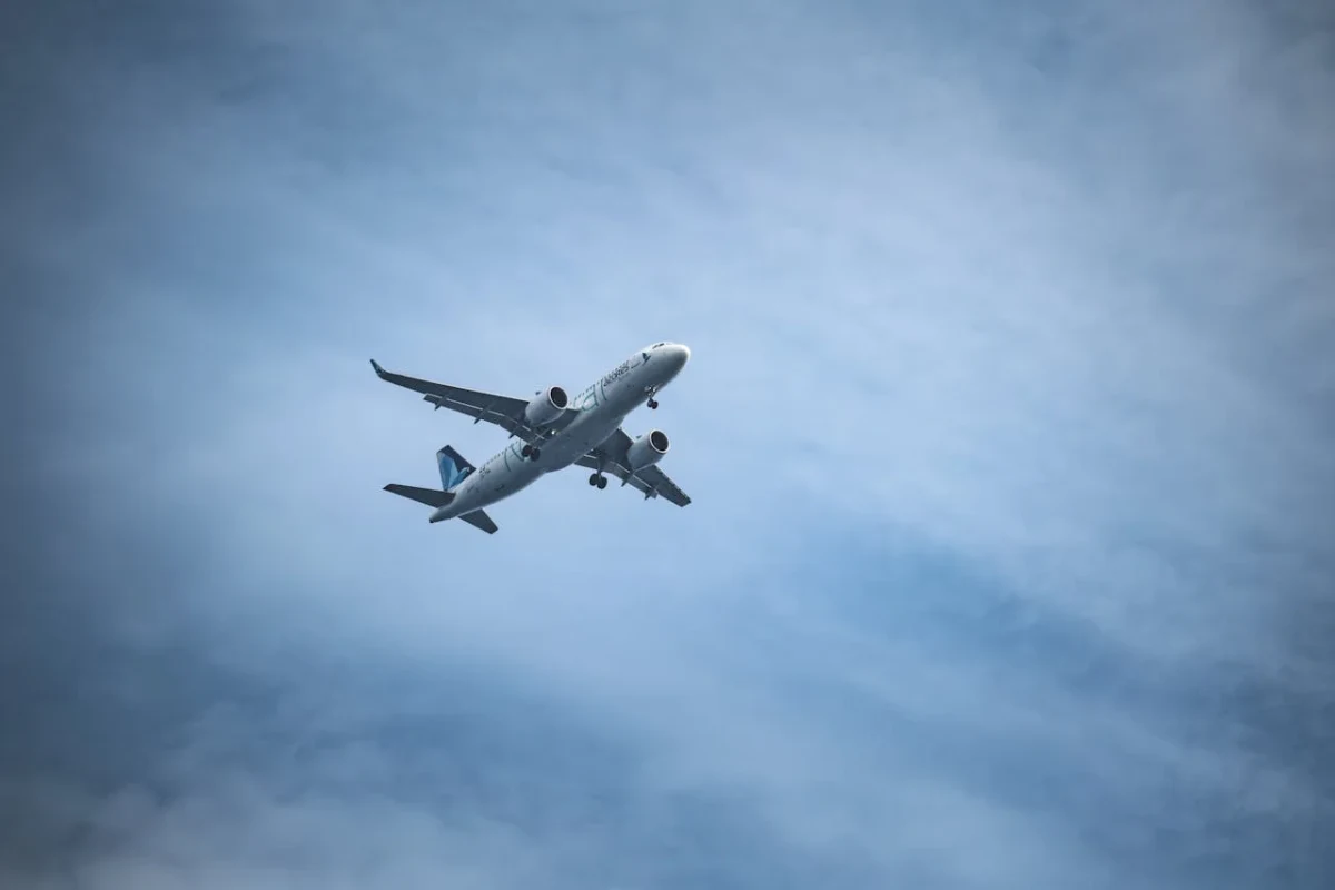 Avión comercial en vuelo sobre cielo parcialmente nublado